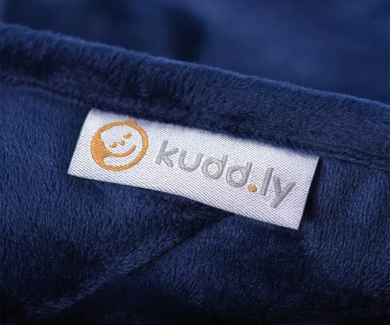 close-up of the kudd.ly tag on a blue blanket