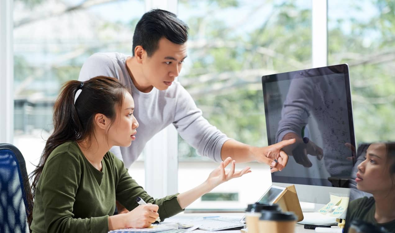 two team members working on a computer