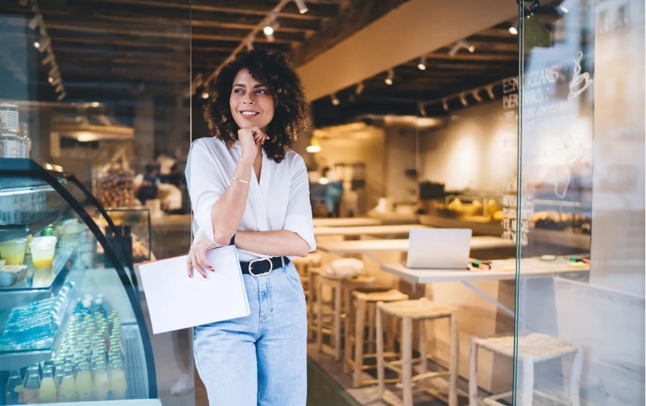 woman standing in the front of a cafe